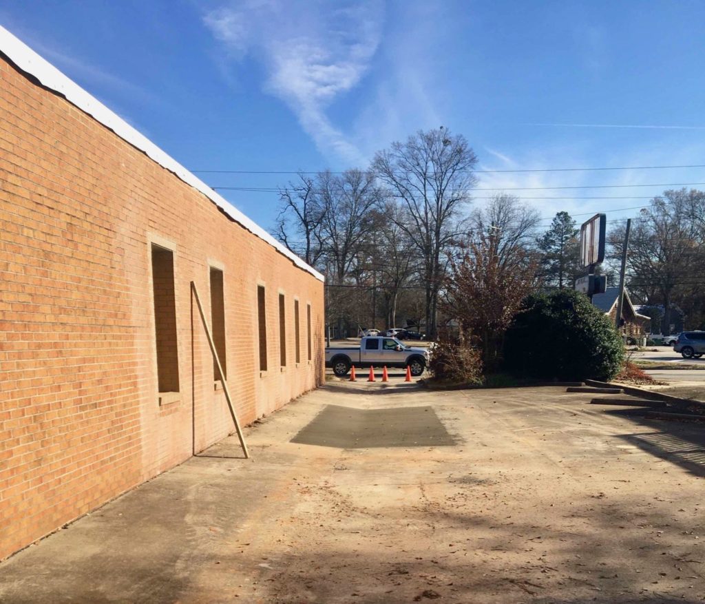 Exterior view of side of office location before brick was painted white for White Oak Pediatric Dentistry in Carrollton, GA.